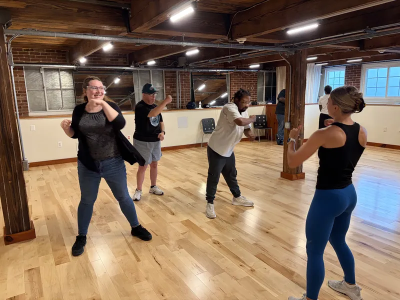 Members and coaches practice punches together in a boxing fitness class